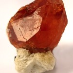 Spessartin, ein Mineral aus der Granat-Gruppe auf Albit