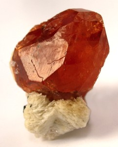 Spessartin, ein Mineral aus der Granat-Gruppe auf Albit